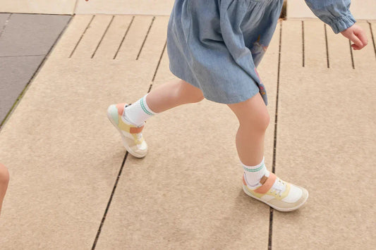 Child walking on a footpath wearing Rafferty’s Barefoot Sneakers in Meadow Mix with white socks.