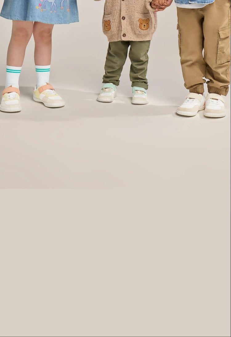 Cropped studio image of children’s legs and feet in Rafferty’s Barefoot 1 kids barefoot shoes in different colourways.