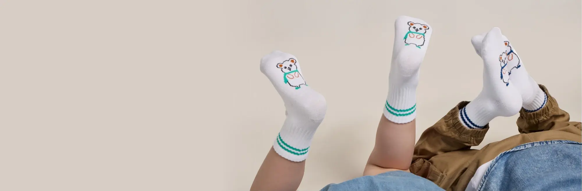 Children wearing Rafferty’s Socks with striped cuffs and teddy bear design, shown in a lifestyle flat-lay style image.