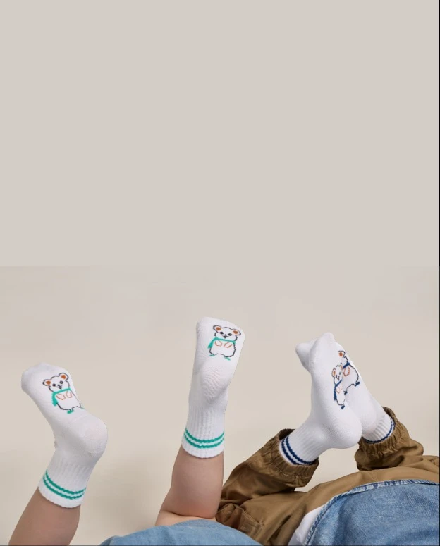 Portrait image of children wearing Rafferty’s Socks with striped cuffs and teddy bear design.